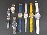 Plusieurs montres différentes sont alignées sur une surface noire