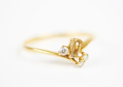 a close up of a gold ring with diamonds on a white background