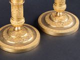 pair of antique brass candlesticks on a black background