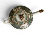 a tea pot with a handle on a white surface