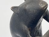 a statue of a bear that is holding a surfboard