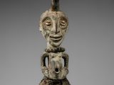 une statue en bois représentant un homme tenant un bébé dans ses bras