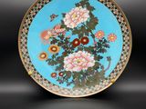 une assiette bleue et dorée ornée de fleurs et d'oiseaux