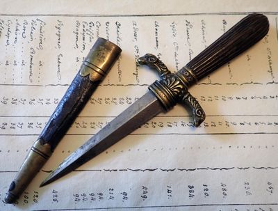 un couteau et un stylo posés sur une feuille de papier