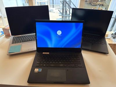 trois ordinateurs portables posés les uns à côté des autres sur une table
