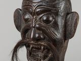 an old wooden sculpture of a man with a moustache on his face