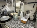 un plan de travail de cuisine sur lequel sont posés de nombreux plats et ustensiles