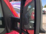 reflection of a person in a car ' s side view mirror in a parking lot