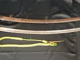 un gros plan d'un couteau et d'une corde posés sur un tissu noir