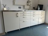 a white cabinet with drawers and a mirror on the wall