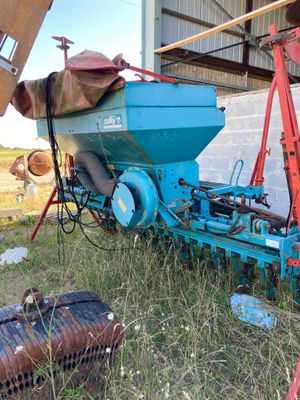 a blue machine that is sitting in the grass