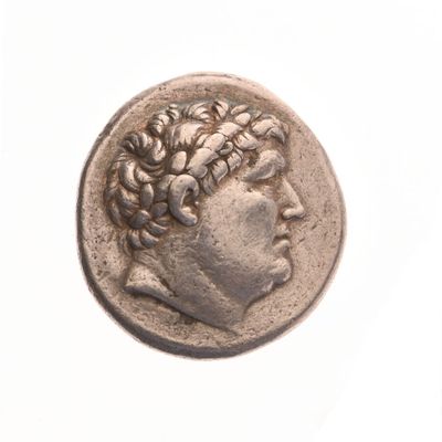 une vieille pièce de monnaie sur laquelle figure la tête d'un homme, sur un fond blanc