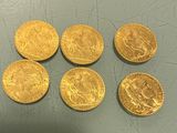 six gold sovereigns of various sizes and shapes