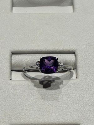 une bague sertie d'une pierre violette, dans un écrin