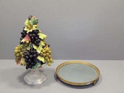 un petit sapin de Noël orné de grappes de raisin, à côté d'un miroir