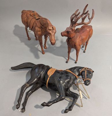 trois figurines représentant des chevaux et un chien posées sur une table