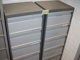 two metal filing cabinets in a room with a brick wall