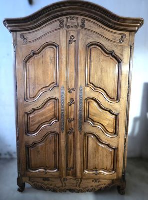 une armoire en bois dans une pièce aux murs blancs