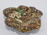 a decorative bowl with flowers on it on a white surface