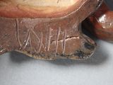 a brown vase with writing on it sitting on a table