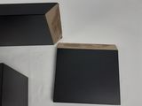 three black boxes with a wooden block on top of them