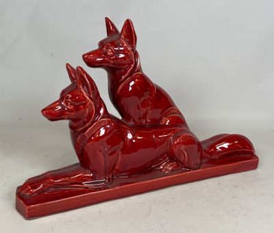 a red statue of two dogs sitting on top of a table