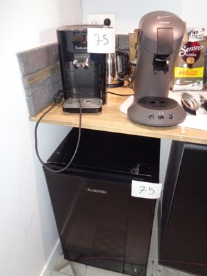 une cafetière posée sur une étagère à côté d'un réfrigérateur