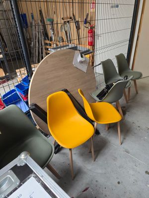 de nombreuses chaises et une table dans une pièce où se trouve une cage