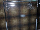 a rack with clothes hanging on it in a bathroom