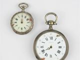 two clocks sitting next to each other on a white surface