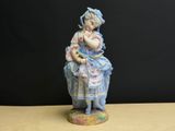 une figurine représentant une petite fille tenant un chat dans ses bras