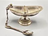 a silver plate with a spoon and spoon rest on it