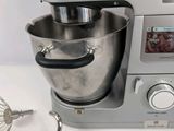 a silver mixer and a whisk on a white table
