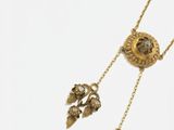gros plan d'un collier en or sur fond blanc