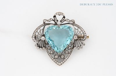 un gros plan d'une broche bleue en forme de cœur sur fond blanc