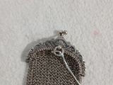 un petit porte-monnaie en argent muni d'une étiquette