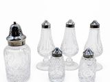 quatre salières et poivrières en verre et une salière en verre
