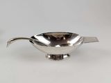 an image of a silver sauce boat on a white surface