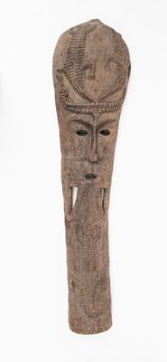une sculpture sur bois représentant le visage d'un homme sur fond blanc