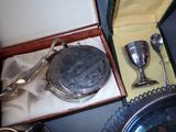 a silver plate with a silver spoon and a silver cup in it