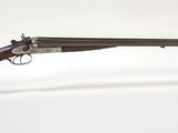 un vieux pistolet au canon en bois, posé sur un socle en acrylique transparent