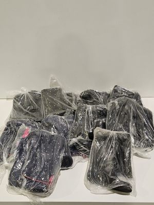 une pile de vêtements emballés dans des sacs en plastique posée sur une table