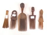 five wooden combs and a brush on a white surface
