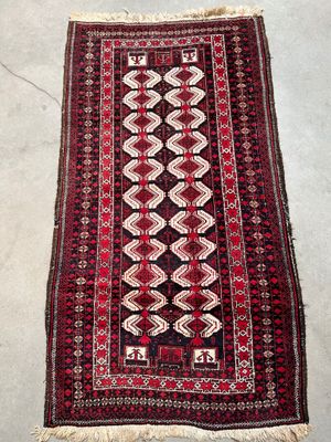 a red and black rug with a diamond design on it