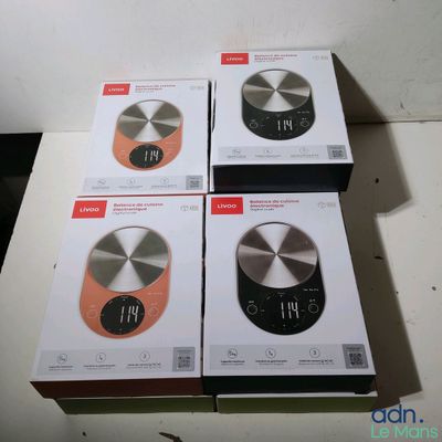 trois boîtes contenant des balances de cuisine électroniques posées sur une table
