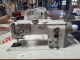 a white sewing machine sitting on a table in a warehouse