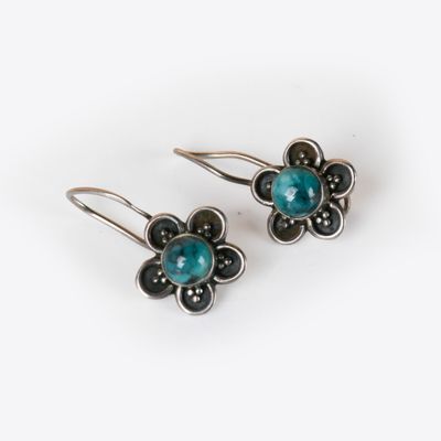 une paire de boucles d'oreilles en argent et turquoise sur fond blanc