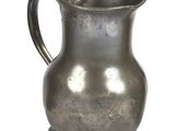 a silver pitcher that is sitting on a white surface