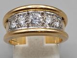 a close up of a gold and diamond ring on a white surface