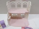 a small doll house with a bench and a doll house on the table